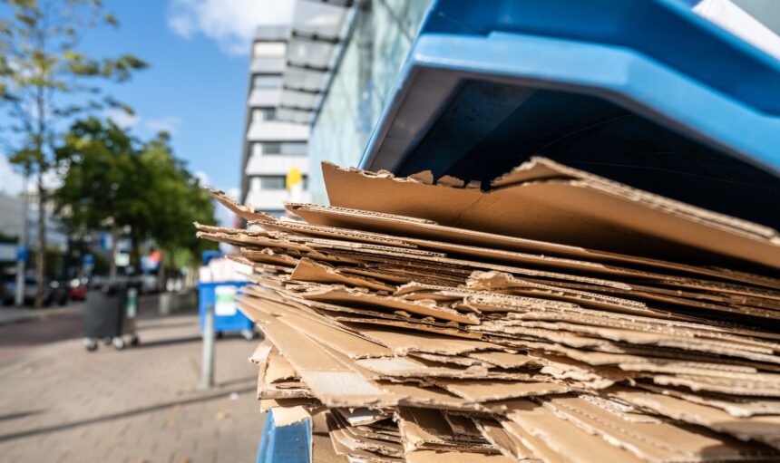 Used cardboard boxes to be collected in a plastic container for paper waste separation recycling.